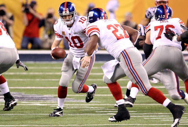 INDIANAPOLIS, IN - FEBRUARY 05:  Quarterback Eli Manning #10 of the New York Giants looks to hand off the ball to runningback Brandon Jacobs #27 in the first quarter against the New England Patriots during Super Bowl XLVI at Lucas Oil Stadium on February 5, 2012 in Indianapolis, Indiana.  (Photo by Andy Lyons/Getty Images)