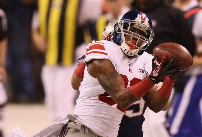 INDIANAPOLIS, IN - FEBRUARY 05:  Mario Manningham #82 of the New York Giants makes a catch on the sidelines against Sterling Moore #29 of the New England Patriots for a gain of 39 yards in the fourth quarter during Super Bowl XLVI at Lucas Oil Stadium on February 5, 2012 in Indianapolis, Indiana.  (Photo by Win McNamee/Getty Images)
