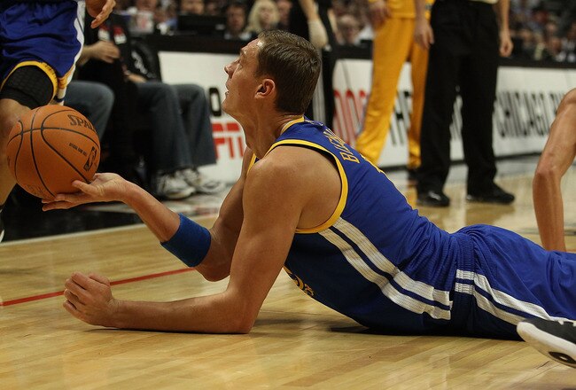 CHICAGO - NOVEMBER 11: Andris Biedrins #15 of the Golden State Warriors hands the ball off to a teammate after a scramble on the floor against the Chicago Bulls at the United Center on November 11, 2010 in Chicago, Illinois. NOTE TO USER: User expressly acknowledges and agrees that, by downloading and/or using this Photograph, User is consenting to the terms and conditions of the Getty Images License Agreement. (Photo by Jonathan Daniel/Getty Images)
