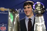 INDIANAPOLIS, IN - FEBRUARY 06:  In this General Motors handout, Eli Manning #10 of the New York Giants poses with the Super Bowl Championship Lombardi Trophy (right) and the Pete Rozelle Trophy for being the Super Bowl XLVI Most Valuable Player after defeating the New England Patriots during Super Bowl XLVI on February 6, 2012 in Indianapolis, Indiana. Manning, named MVP, led the Giants to a 21-17 victory.  (Photo by AJ Mast/General Motors via Getty Images)