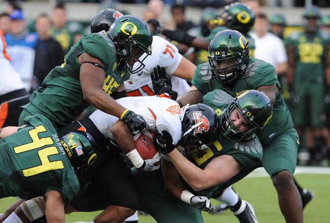 EUGENE, OR - NOVEMBER 26: Running back Jovan Stevenson #19 of the Oregon State Beavers is gang tackled by defensive end Brandon Hanna #44, defensive end Terrell Turner #45 o and defensive tackle Taylor Hart #66 of the Oregon Ducks in the second quarter of the game at Autzen Stadium on November 26, 2011 in Eugene, Oregon. (Photo by Steve Dykes/Getty Images)