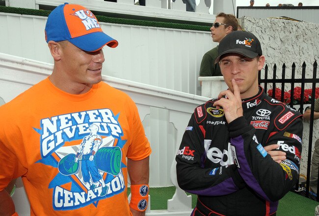 LONG POND, PA - JUNE 06:  WWE champion and co-grand marshal John Cena (L) and Denny Hamlin, driver of the #11 FedEx Freight Toyota, talk in Victory Lane prior to the NASCAR Sprint Cup Series Gillette Fusion ProGlide 500 at Pocono Raceway on June 6, 2010 in Long Pond, Pennsylvania.  (Photo by Drew Hallowell/Getty Images for NASCAR)