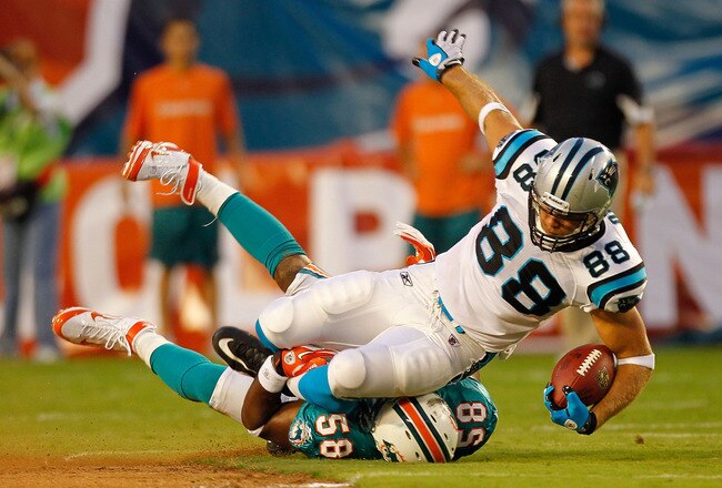 MIAMI GARDENS, FL - AUGUST 19:  Greg Olsen #88 of the Carolina Panthers is tackled by Karlos Dansby #58 of the Miami Dolphins during a Preseason NFL game  at Sun Life Stadium on August 19, 2011 in Miami Gardens, Florida.  (Photo by Mike Ehrmann/Getty Images)