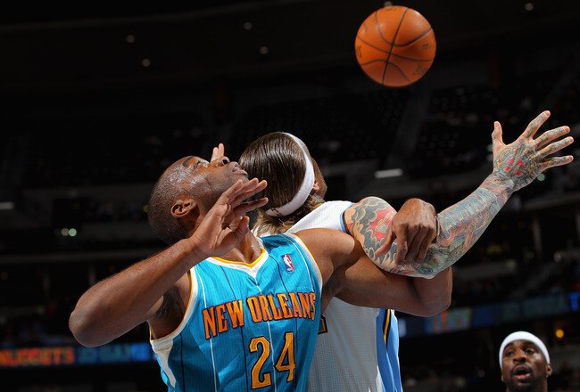 DENVER, CO - JANUARY 09:  Carl Landry #24 of the New Orleans Hornets and Chris Andersen #11 of the Denver Nuggets battle for a rebound at the Pepsi Center on January 9, 2012 in Denver, Colorado. NOTE TO USER: User expressly acknowledges and agrees that, by downloading and or using this photograph, User is consenting to the terms and conditions of the Getty Images License Agreement.  (Photo by Doug Pensinger/Getty Images)