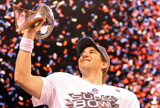 INDIANAPOLIS, IN - FEBRUARY 05:  Quarterback Eli Manning #10 of the New York Giants poses with the Vince Lombardi Trophy after the Giants defeated the Patriots by a score of 21-17 in Super Bowl XLVI at Lucas Oil Stadium on February 5, 2012 in Indianapolis, Indiana.  (Photo by Ezra Shaw/Getty Images)
