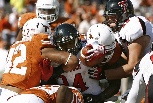 AUSTIN, TX - NOVEMBER 5: Running back Kenny Williams #34 of the Texas Tech Red Raiders is stopped from scoring on the goal line in the fourth quarter by linebacker Tevin Jackson #42 and other Texas Longhorn defenders on November 5, 2011 at Darrell K. Royal-Texas Memorial Stadium in Austin, Texas. Texas beat Texas Tech 52-20. (Photo by Erich Schlegel/Getty Images)