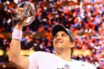 INDIANAPOLIS, IN - FEBRUARY 05:  Eli Manning #10 of the New York Giants hoist the Vince Lombardi Trophy after defeating the New England Patriots in Super Bowl XLVI at Lucas Oil Stadium on February 5, 2012 in Indianapolis, Indiana. The New York Giants defeated the New England Patriots 21-17.  (Photo by Al Bello/Getty Images)