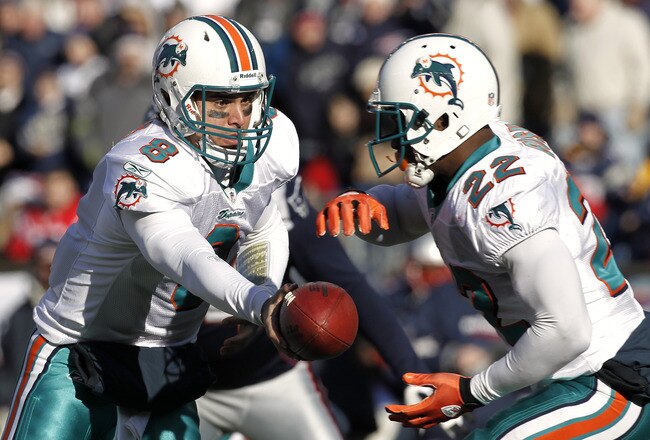 FOXBORO, MA - DECEMBER 24:  Matt Moore #8 of the Miami Dolphins hands the ball off to Reggie Bush #22 during the first quarter against the New England Patriots at Gillette Stadium on December 24, 2011 in Foxboro, Massachusetts.  (Photo by Winslow Townson/Getty Images)