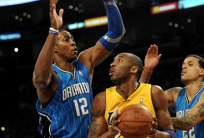 LOS ANGELES, CA - JANUARY 18:  Kobe Bryant #24 of the Los Angeles Lakers handles the ball against Dwight Howard #12 and Matt Barnes #22 of the Orlando Magic in the first quarter during the game on January 18, 2010 at Staples Center in Los Angeles, California. NOTE TO USER: User expressly acknowledges and agrees that, by downloading and/or using this Photograph, user is consenting to the terms and conditions of the Getty Images License Agreement.  (Photo by Harry How/Getty Images)