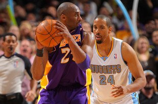 DENVER, CO - FEBRUARY 03:  Kobe Bryant #24 of the Los Angeles Lakers bites his jersey as he controls the ball against Andre Miller #24 of the Denver Nuggets at the Pepsi Center on February 3, 2012 in Denver, Colorado. The Lakers defeated the Nuggets 93-89. NOTE TO USER: User expressly acknowledges and agrees that, by downloading and or using this photograph, User is consenting to the terms and conditions of the Getty Images License Agreement.  (Photo by Doug Pensinger/Getty Images)