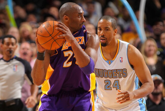 DENVER, CO - FEBRUARY 03:  Kobe Bryant #24 of the Los Angeles Lakers bites his jersey as he controls the ball against Andre Miller #24 of the Denver Nuggets at the Pepsi Center on February 3, 2012 in Denver, Colorado. The Lakers defeated the Nuggets 93-89. NOTE TO USER: User expressly acknowledges and agrees that, by downloading and or using this photograph, User is consenting to the terms and conditions of the Getty Images License Agreement.  (Photo by Doug Pensinger/Getty Images)