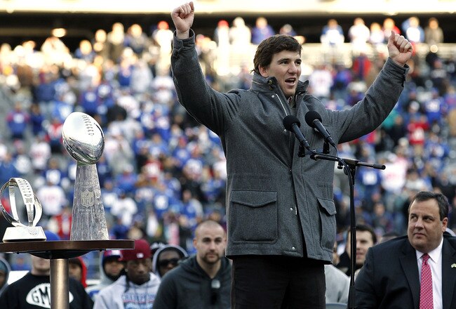 EAST RUTHERFORD, NJ - FEBRUARY 07:  Eli Manning #10 (L) of the New York Giants speaks to fans as New Jersey Governor Chris Christie looks on at a rally to celebrate the New York Giants' Super Bowl victory at MetLife Stadium on February 7, 2012 in East Rutherford, New Jersey. The Giants defeated the New England Patriots 21-17 in Super Bowl XLVI at Lucas Oil Stadium on February 5, 2012 in Indianapolis, Indiana.  (Photo by Jeff Zelevansky/Getty Images)