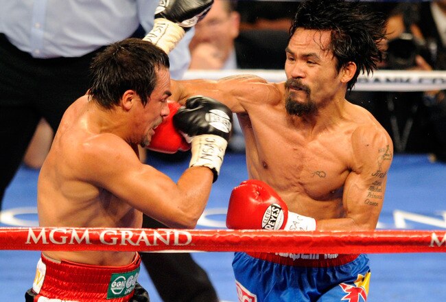 LAS VEGAS, NV - NOVEMBER 12:  Manny Pacquiao (R) throws a right at Juan Manuel Marquez during the fourth round of their WBO world welterweight title fight at the MGM Grand Garden Arena November 12, 2011 in Las Vegas, Nevada. Pacquiao retained his title with a majority decision victory.  (Photo by Ethan Miller/Getty Images)