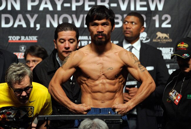 LAS VEGAS, NV - NOVEMBER 11:  (C) Boxer Manny Pacquiao steps on the scale to weigh 143 pounds as trainer (L) Freddie Roach looks at the scale during the official weigh-in for his bout against Juan Manuel Marquez at the MGM Grand Garden Arena November 11, 2011 in Las Vegas, Nevada. Pacquiao will defend his WBO welterweight title against Marquez when the two meet in the ring for the third time on November 12 in Las Vegas.  (Photo by Ethan Miller/Getty Images)
