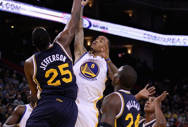 OAKLAND, CA - JANUARY 07:  Monta Ellis #8 of the Golden State Warriors shoots over Al Jefferson #25 of the Utah Jazz at Oracle Arena on January 7, 2012 in Oakland, California.  NOTE TO USER: User expressly acknowledges and agrees that, by downloading and or using this photograph, User is consenting to the terms and conditions of the Getty Images License Agreement.  (Photo by Ezra Shaw/Getty Images)