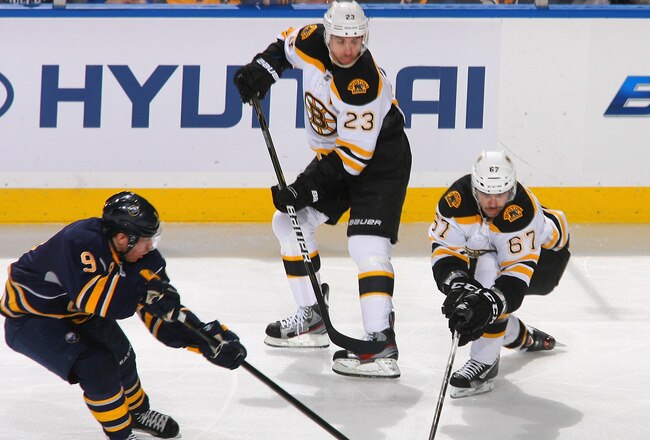 BUFFALO, NY - NOVEMBER 23: Benoit Pouliot #67 and Chris Kelly #23 of the Boston Bruins skate against Derek Roy #9 of the Buffalo Sabres at First Niagara Center on November 23, 2011 in Buffalo, New York.  (Photo by Rick Stewart/Getty Images)