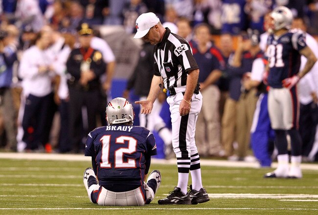 INDIANAPOLIS, IN - FEBRUARY 05:  Tom Brady #12 of the New England Patriots sits on the ground after throwing an interception to Chase Blackburn #93 of the New York Giants over Rob Gronkowski #87 at the 8 yard line in the fourth quarter during Super Bowl XLVI at Lucas Oil Stadium on February 5, 2012 in Indianapolis, Indiana.  (Photo by Al Bello/Getty Images)