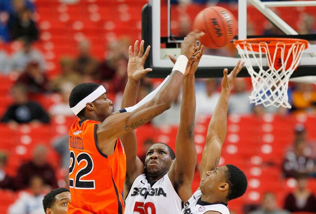 ATLANTA, GA - MARCH 10:  Kenny Gabriel #22 of the Auburn Tigers shoots over Gerald Robinson #22 and Jeremy Price #50 of the Georgia Bulldogs during the the first round of the SEC Men's Basketball Tournament at the Georgia Dome on March 10, 2011 in Atlanta, Georgia.  (Photo by Kevin C. Cox/Getty Images)