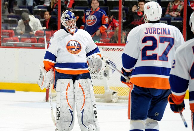WASHINGTON, DC - JANUARY 17:  Evgeni Nabokov #20 of the New York Islanders is congratulated by teammates after a 3-0 victory against the Washington Capitals at the Verizon Center on January 17, 2012 in Washington, DC.  (Photo by Greg Fiume/Getty Images)