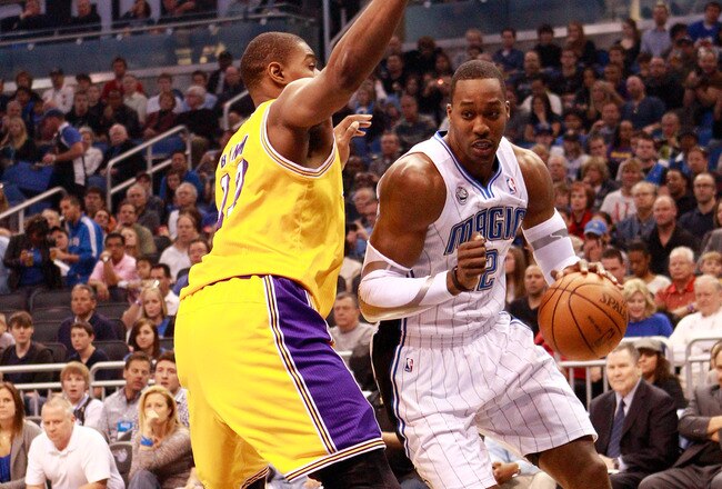ORLANDO, FL - FEBRUARY 13:  Dwight Howard #12 of the Orlando Magic drives against Andrew Bynum #17 of the Los Angeles Lakers during the game at Amway Arena on February 13, 2011 in Orlando, Florida.  NOTE TO USER: User expressly acknowledges and agrees that, by downloading and or using this Photograph, user is consenting to the terms and conditions of the Getty Images License Agreement.  (Photo by Sam Greenwood/Getty Images)