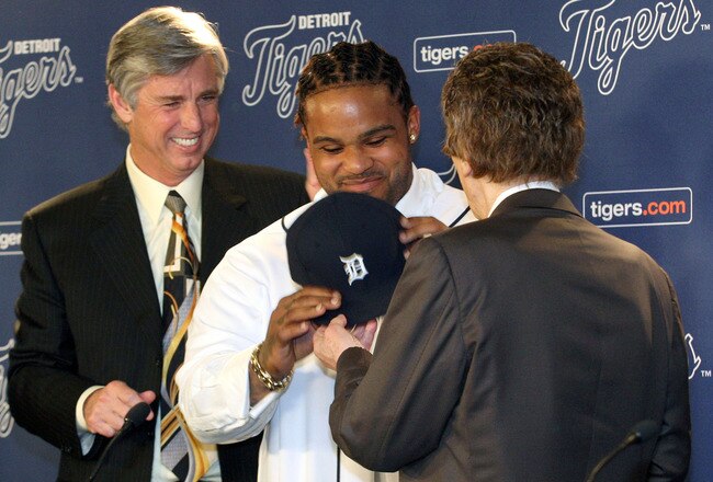 DETROIT, MI - JANUARY 26:  Prince Fielder #28 of the Detroit Tigers puts on his jersey, helped by CEO and general manager Dave Dombrowski (L) and owner Mike Ilitch during a press conference at Comerica Park on January 26, 2012 in Detroit, Michigan.  (Photo by Jorge Lemus/Getty Images)