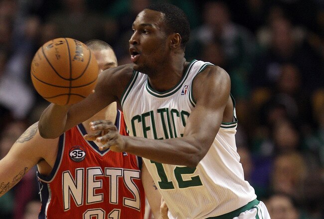 BOSTON, MA - JANUARY 04:  JaJuan Johnson #12 of the Boston Celtics passes the ball as Dennis Horner #31 of the New Jersey Nets defends on January 4, 2012 at TD Garden in Boston, Massachusetts. The Boston Celtics defeated the New Jersey Nets 89-70. NOTE TO USER: User expressly acknowledges and agrees that, by downloading and or using this photograph, User is consenting to the terms and conditions of the Getty Images License Agreement.  (Photo by Elsa/Getty Images)