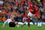 MANCHESTER, ENGLAND - SEPTEMBER 19:   Patrice Evra of Manchester United evades the tackle of Maxi Rodriguez of Liverpool during the Barclays Premier League match between Manchester United and Liverpool at Old Trafford on September 19, 2010 in Manchester, England. (Photo by Alex Livesey/Getty Images)