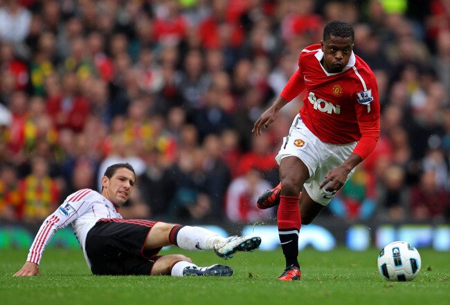 MANCHESTER, ENGLAND - SEPTEMBER 19:   Patrice Evra of Manchester United evades the tackle of Maxi Rodriguez of Liverpool during the Barclays Premier League match between Manchester United and Liverpool at Old Trafford on September 19, 2010 in Manchester, England. (Photo by Alex Livesey/Getty Images)