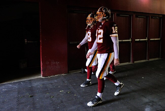 LANDOVER, MD - DECEMBER 04:   Rex Grossman #8 of the Washington Redskins and John Beck #12 of the Washington Redskins walk onto the field before a game against the New York Jets at FedExField on December 4, 2011 in Landover, Maryland.  (Photo by Patrick McDermott/Getty Images)