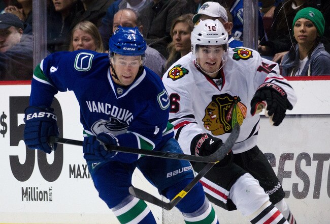 VANCOUVER, CANADA - JANUARY 31: Marcus Kruger #16 of the Chicago Blackhawks tries to check Keith Ballard #4 of the Vancouver Canucks during the third period in NHL action on January 31, 2012 at Rogers Arena in Vancouver, British Columbia, Canada.  (Photo by Rich Lam/Getty Images)