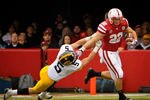 LINCOLN, NE - NOVEMBER 25: Running back Rex Burkhead #22 of the Nebraska Cornhuskers stiff-arms defensive back Tanner Miller #5 of the Iowa Hawkeyes during their game at Memorial Stadium November 25, 2011 in Lincoln, Nebraska. (Photo by Eric Francis/Getty Images)