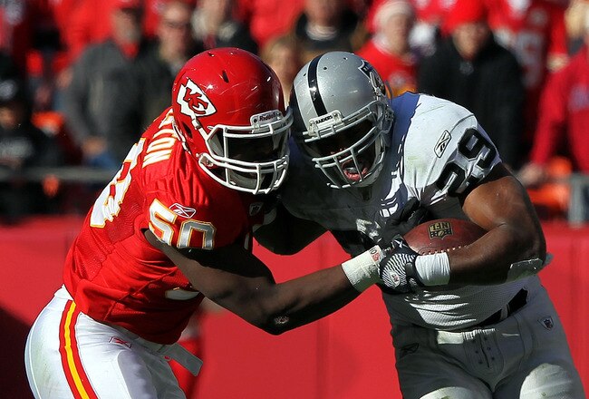 KANSAS CITY, MO - DECEMBER 24:  Justin Houston #50 of the Kansas City Chiefs tackles Michael Bush #29 of the Oakland Raiders as Bush carries the ball upfield during the game on December 24, 2011 at Arrowhead Stadium in Kansas City, Missouri.  (Photo by Jamie Squire/Getty Images)