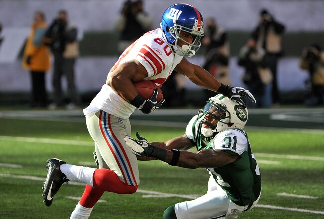 EAST RUTHERFORD, NJ - DECEMBER 24: Victor Cruz #80 of the New York Giants breaks the tackle attempt of Antonio Cromartie #31 of the New York Jets during the first half on December 24, 2011 at MetLife Stadium in East Rutherford, New Jersey. (Photo by Christopher Pasatieri/Getty Images)