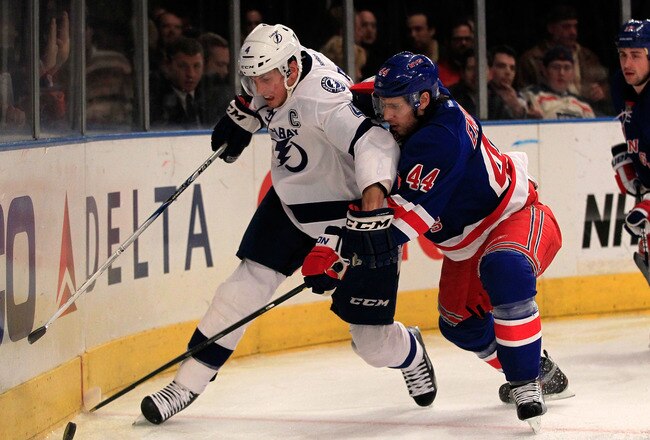 NEW YORK, NY - DECEMBER 08: (L) Vincent Lecavalier #4 of the Tampa Bay Lightning battles with (R) Steve Eminger #44 of the New York Rangers for the puck at Madison Square Garden on December 8, 2011 in New York City.  (Photo by Chris Trotman/Getty Images)