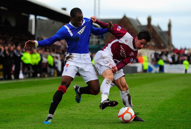 ARBROATH, SCOTLAND - JANUARY 08:  Rangers player Sone Aluko (l) challenges Josh Falkingham of Abroath during the William Hill Scottish Cup Fourth Round match between Arbroath and Rangers at Gayfield park on January 8, 2012 in Arbroath, Scotland.  (Photo by Stu Forster/Getty Images)