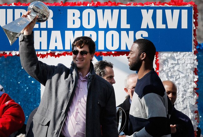 NEW YORK, NY - FEBRUARY 07:  Quarterback Eli Manning #10 (L) of the New York Giants and Super Bowl XLVI MVP holds the Vince Lombardi Trophy as Justin Tuck #91 (R) of the New York Giants looks on during the Giants' Victory Parade on February 7, 2012 in New York City. The Giants defeated the New England Patriots 21-17 in Super Bowl XLVI.  (Photo by Andrew Burton/Getty Images)
