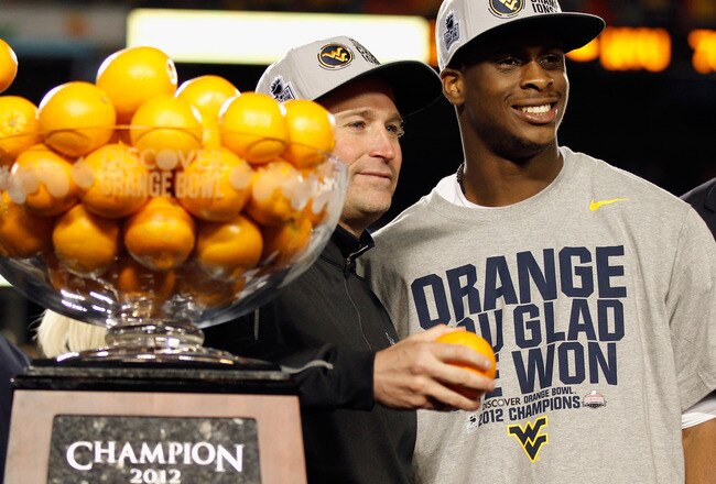 MIAMI GARDENS, FL - JANUARY 04:  (L-R) Head coach Dana Holgorsen and Geno Smith #12 of the West Virginia Mountaineers celebrate with the trophy after they won 70-33 against the Clemson Tigers during the Discover Orange Bowl at Sun Life Stadium on January 4, 2012 in Miami Gardens, Florida.  (Photo by Mike Ehrmann/Getty Images)