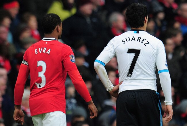 MANCHESTER, ENGLAND - FEBRUARY 11:  Patrice Evra of Manchester United walks with Luis Suarez of Liverpool during the Barclays Premier League match between Manchester United and Liverpool at Old Trafford on February 11, 2012 in Manchester, England.  (Photo by Shaun Botterill/Getty Images)
