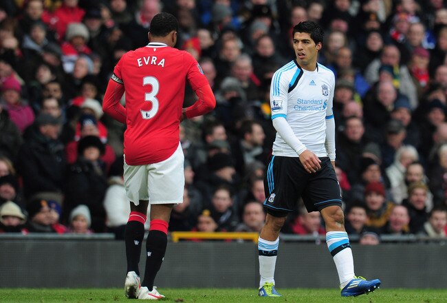 MANCHESTER, ENGLAND - FEBRUARY 11:  Luis Suarez of Liverpool looks at Patrice Evra of Manchester United during the Barclays Premier League match between Manchester United and Liverpool at Old Trafford on February 11, 2012 in Manchester, England.  (Photo by Shaun Botterill/Getty Images)