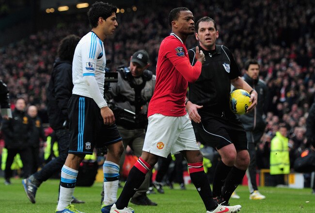 MANCHESTER, ENGLAND - FEBRUARY 11:  Patrice Evra of Manchester United celebrates victory as he walks off with Luis Suarez of Liverpool during the Barclays Premier League match between Manchester United and Liverpool at Old Trafford on February 11, 2012 in Manchester, England.  (Photo by Shaun Botterill/Getty Images)