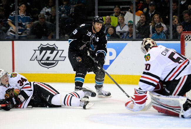 SAN JOSE, CA - FEBRUARY 10:  Joe Thornton #19 of the San Jose Sharks attacks the net against goaltender Corey Crawford #50 of the Chicago Blackhawks  at HP Pavilion at San Jose on February 10, 2012 in San Jose, California.  (Photo by Thearon W. Henderson/Getty Images)