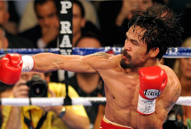 LAS VEGAS, NV - NOVEMBER 12:  Manny Pacquiao (R) throws a right at Juan Manuel Marquez during the seventh round of their WBO world welterweight title fight at the MGM Grand Garden Arena November 12, 2011 in Las Vegas, Nevada. Pacquiao retained his title with a majority decision victory.  (Photo by Ethan Miller/Getty Images)