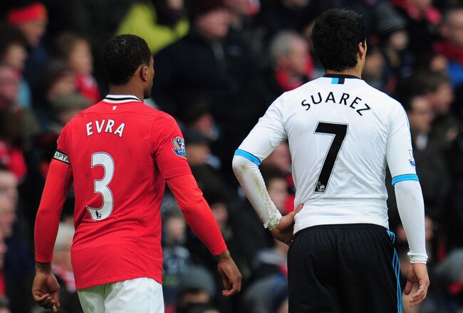 MANCHESTER, ENGLAND - FEBRUARY 11:  Patrice Evra of Manchester United walks with Luis Suarez of Liverpool during the Barclays Premier League match between Manchester United and Liverpool at Old Trafford on February 11, 2012 in Manchester, England.  (Photo by Shaun Botterill/Getty Images)