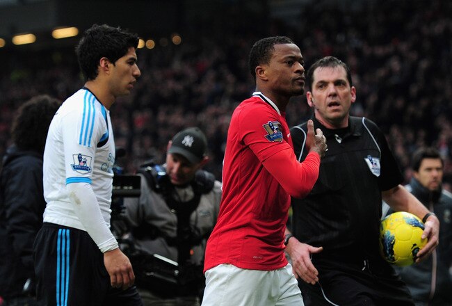 MANCHESTER, ENGLAND - FEBRUARY 11:  Patrice Evra of Manchester United celebrates victory as he walks off with Luis Suarez of Liverpool during the Barclays Premier League match between Manchester United and Liverpool at Old Trafford on February 11, 2012 in Manchester, England.  (Photo by Shaun Botterill/Getty Images)