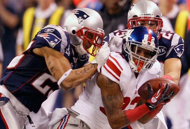 INDIANAPOLIS, IN - FEBRUARY 05:  Mario Manningham #82 of the New York Giants makes a catch on the sidelines against Patrick Chung #25 and Sterling Moore #29 of the New England Patriots for a gain of 39 yards in the fourth quarter during Super Bowl XLVI at Lucas Oil Stadium on February 5, 2012 in Indianapolis, Indiana.  (Photo by Rob Carr/Getty Images)