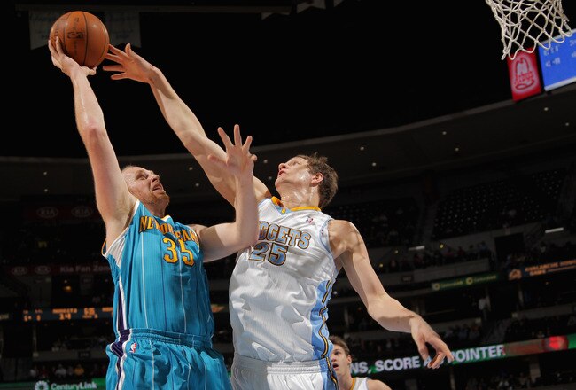 DENVER, CO - JANUARY 09:  Chris Kaman #35 of the New Orleans Hornets tries to get off a shot against Timofey Mozgov #25 of the Denver Nuggets at the Pepsi Center on January 9, 2012 in Denver, Colorado. NOTE TO USER: User expressly acknowledges and agrees that, by downloading and or using this photograph, User is consenting to the terms and conditions of the Getty Images License Agreement.  (Photo by Doug Pensinger/Getty Images)