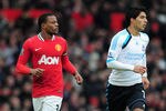 MANCHESTER, ENGLAND - FEBRUARY 11:  Patrice Evra of Manchester United jogs with Luis Suarez of Liverpool during the Barclays Premier League match between Manchester United and Liverpool at Old Trafford on February 11, 2012 in Manchester, England.  (Photo by Shaun Botterill/Getty Images)