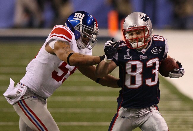 INDIANAPOLIS, IN - FEBRUARY 05:  Wes Welker #83 of the New England Patriots fights off the tackle of Michael Boley #59 of the New York Giants  in the first half during Super Bowl XLVI at Lucas Oil Stadium on February 5, 2012 in Indianapolis, Indiana.  (Photo by Win McNamee/Getty Images)