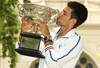 MELBOURNE, AUSTRALIA - JANUARY 30:  Novak Djokovic of Serbia poses with the Norman Brookes Challenge Cup after winning the 2012 men's Australian Open, at Carlton Gardens on January 30, 2012 in Melbourne, Australia.  (Photo by Lucas Dawson/Getty Images)