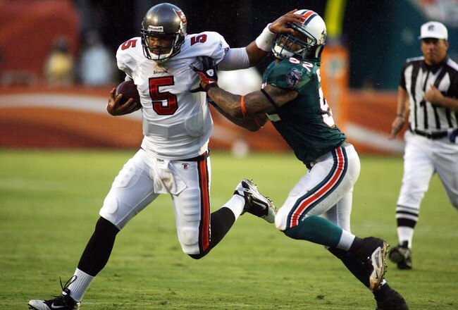 MIAMI - AUGUST 14:  Linebacker Channing Crowder #52 of the Miami Dolphins (R) tackles Quarterback Josh Freemen #5 of the Tampa Bay Buccaneers during the preseason game at Sun Life Stadium on August 14, 2010 in Miami, Florida.  (Photo by Marc Serota/Getty Images)